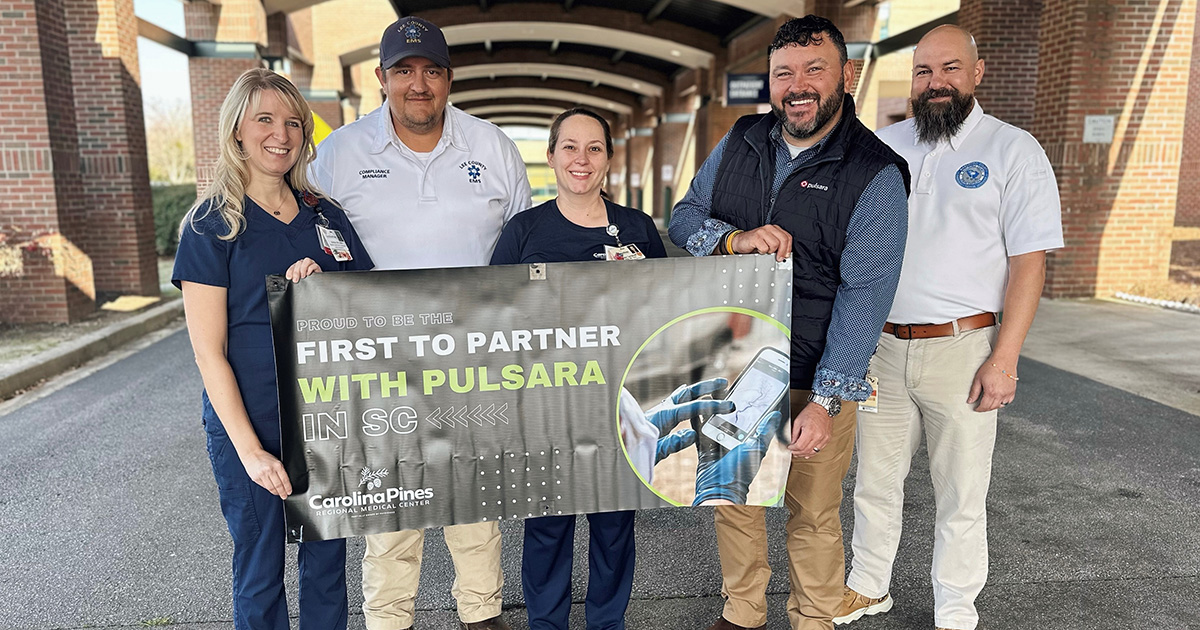 Carolina Pines staff hold up a banner about their hospital's partnership with Pulsara