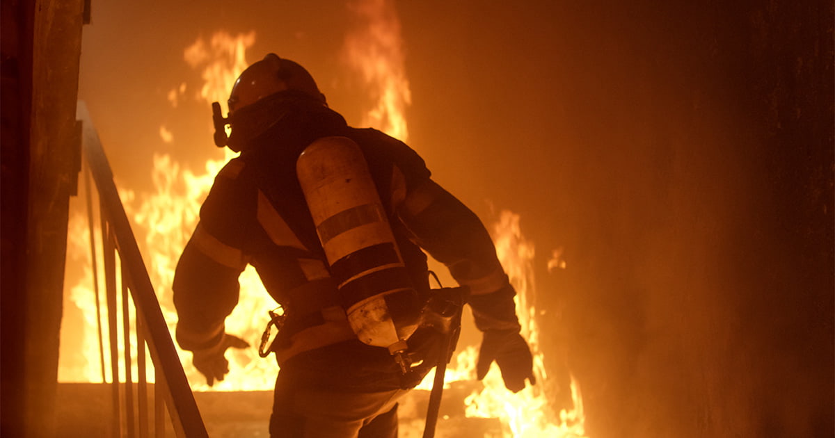 a firefighter enters a blaze